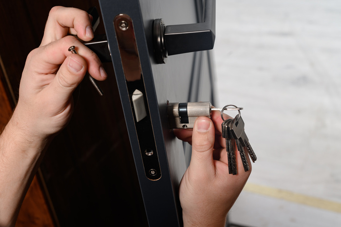 residential locksmith hands installing door lock