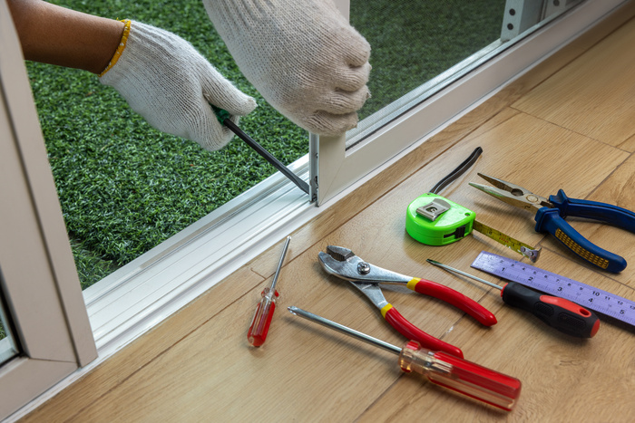 Worker fixing the insect screen sliding door